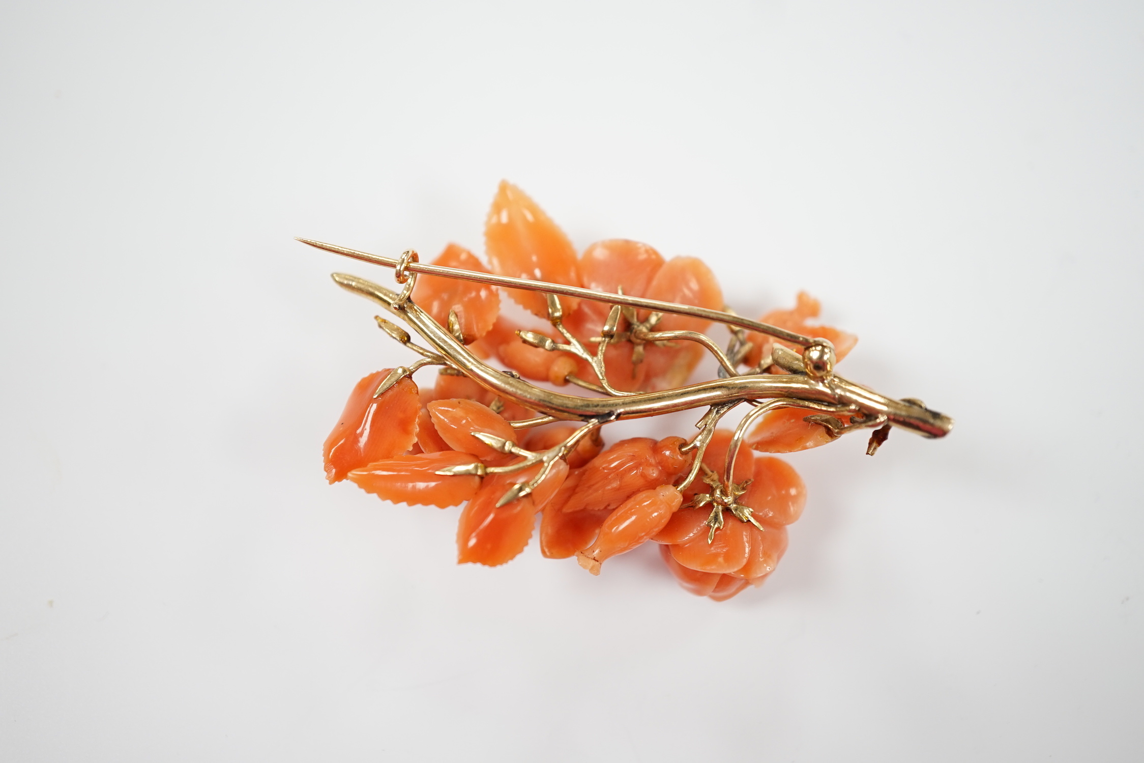 A yellow metal mounted carved coral floral spray brooch(a.f.), 64mm.